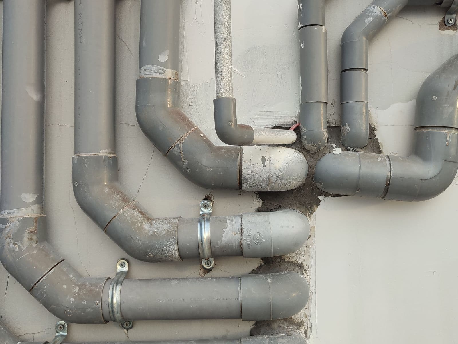 CPVC and PVC pipes and fittings installed along a wall